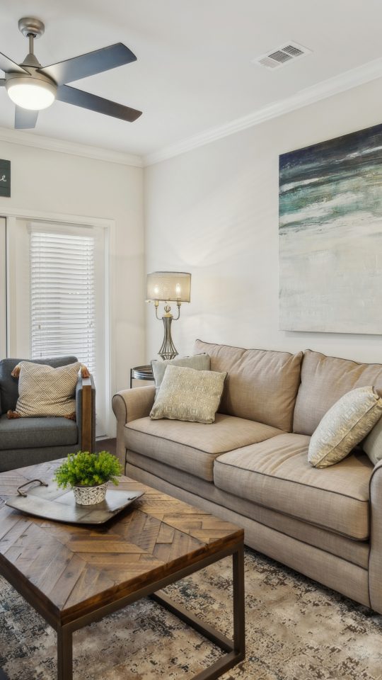 the living room has a ceiling fan and a couch at The Auberge of Burleson