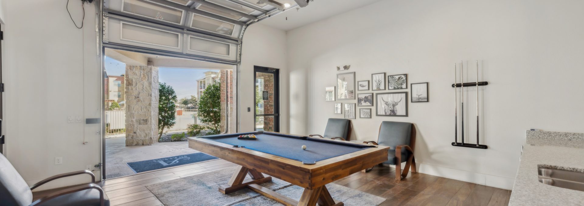 a pool table in a home with a garage door at The Auberge of Burleson
