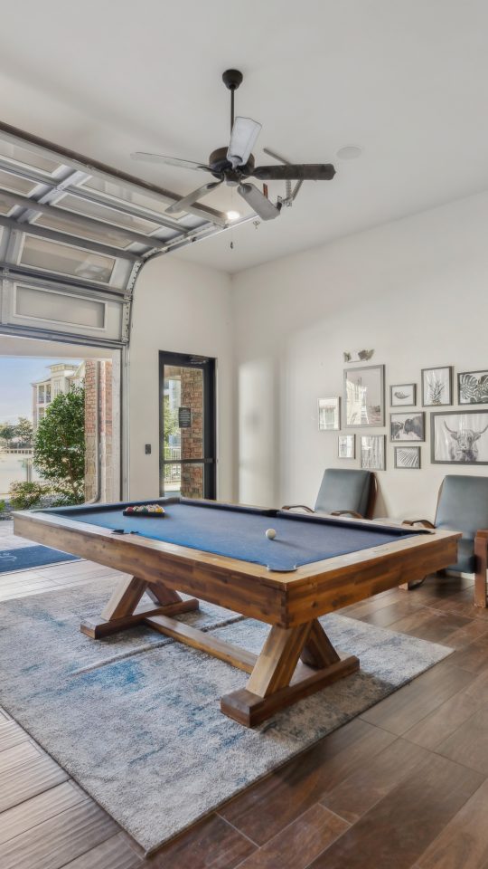 a pool table in a home with a garage door at The Auberge of Burleson