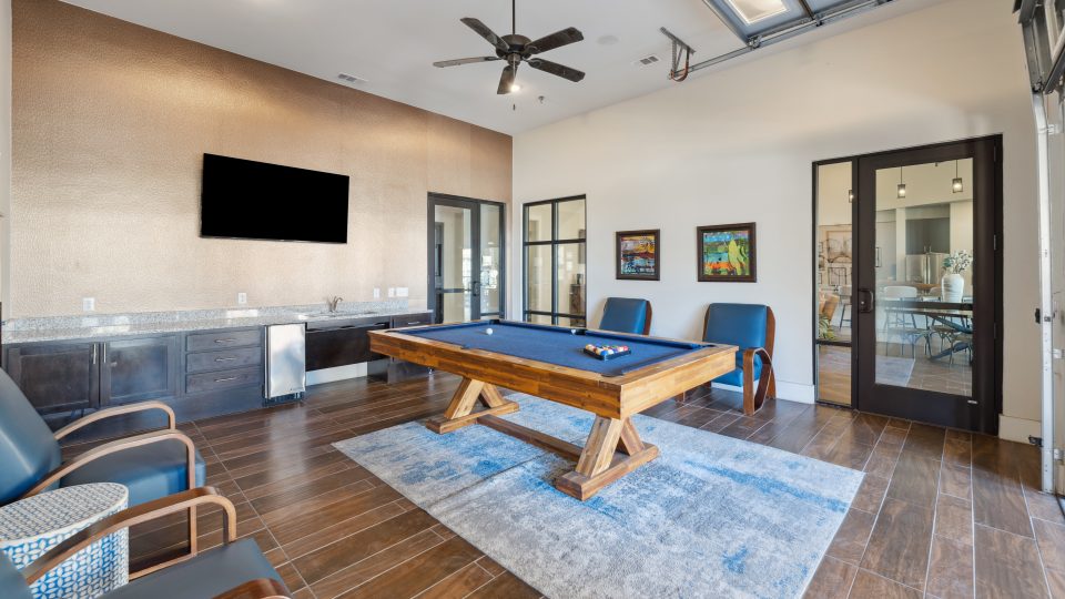 pool table in a living room with blue chairs at The Auberge of Burleson